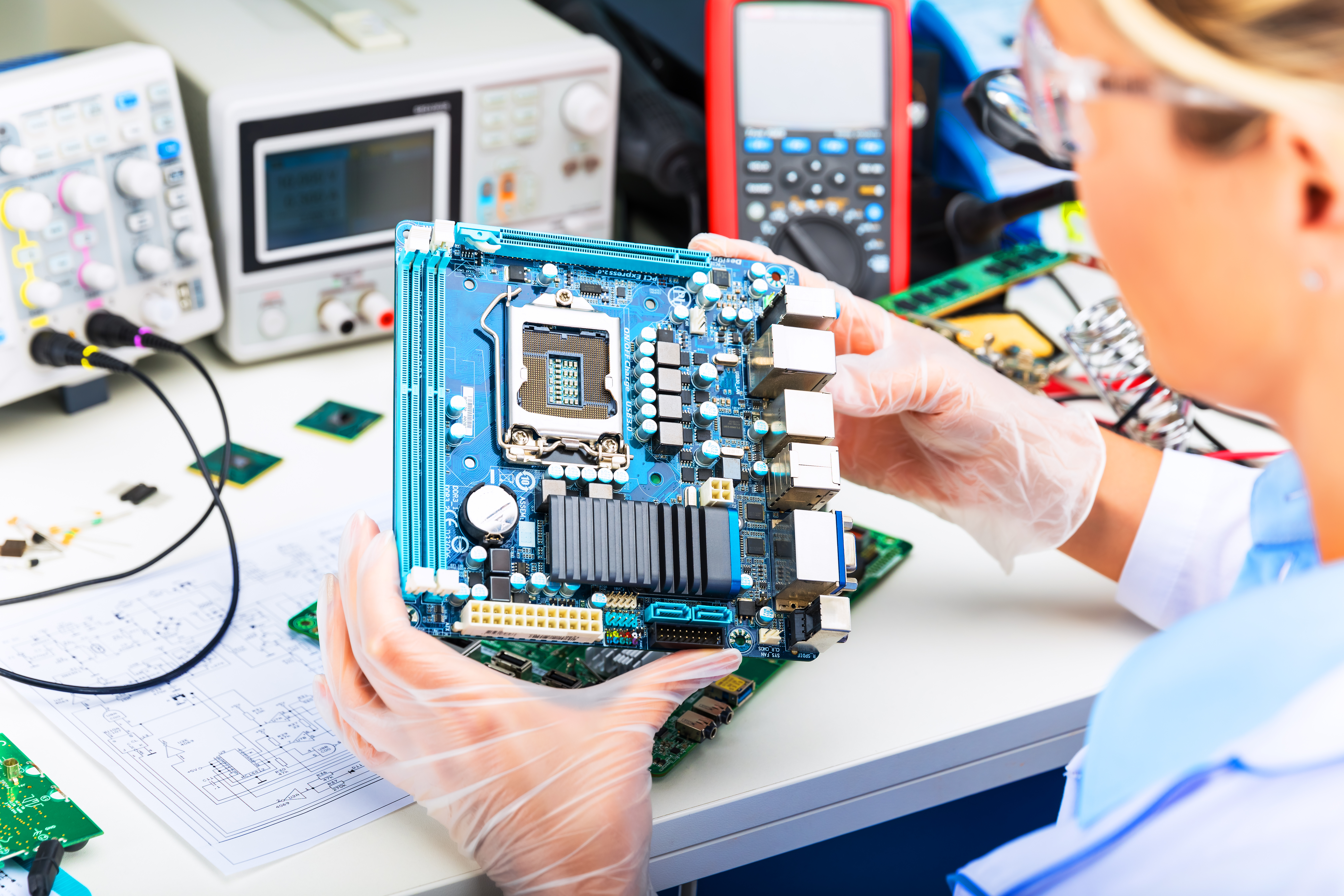 Elektronikerin bei der Untersuchung einer Computer-Hauptplatine im Labor