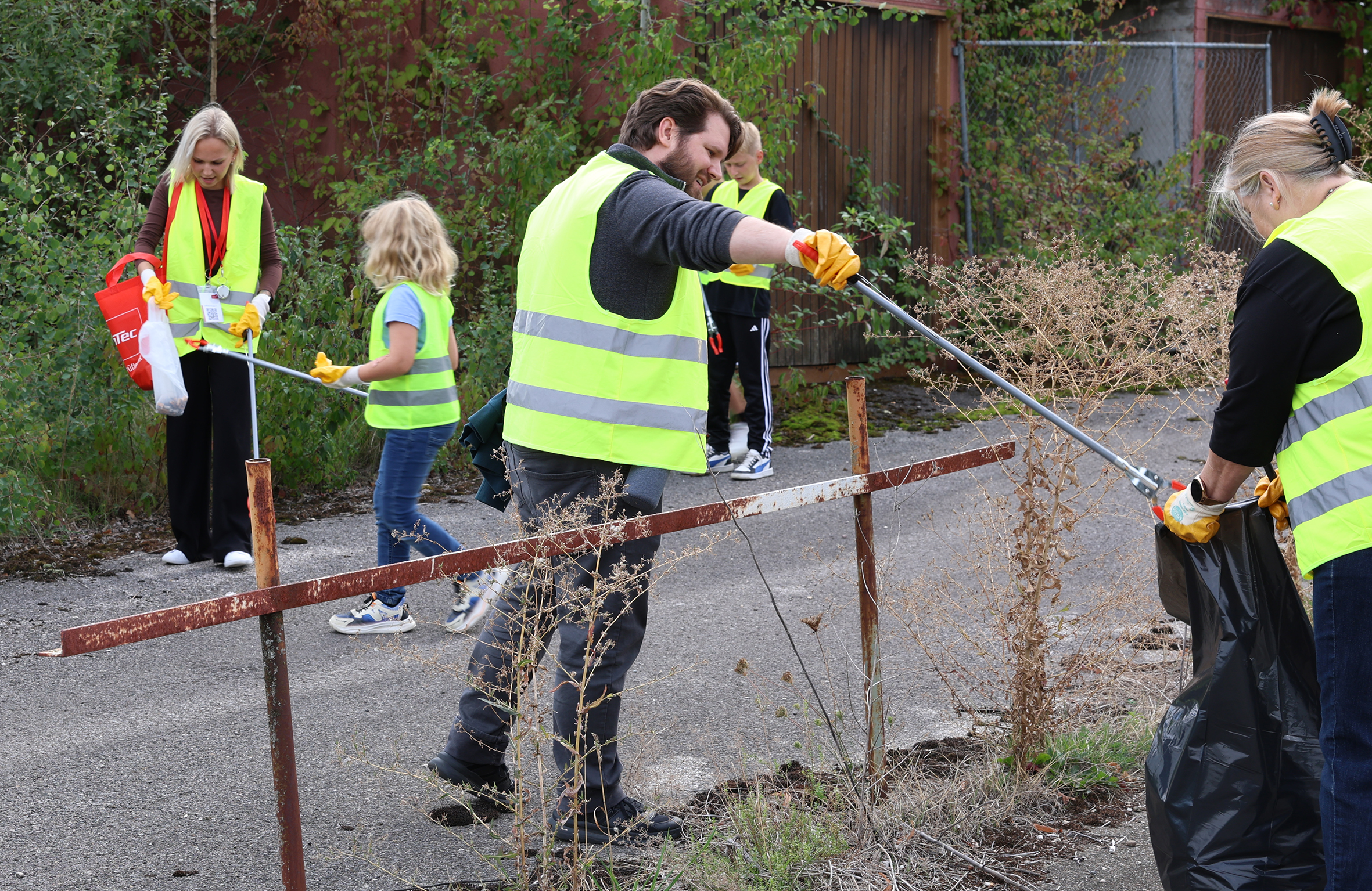 Mitarbeitende von dataTec und ein Kind sammeln beim World Cleanup Day 2026 mit Greifzangen Müll entlang eines Weges.